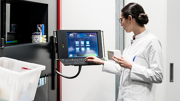 KI im Gesundheitswesen - Roboter ersetzen keine Menschen Low-angle rear view of an experienced female pharmacist using a computer while managing the drug stock in a contemporary pharmacy with modern technology