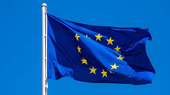 Neues aus dem Herzen der EU - Europaflagge Foto zum Thema "Neues aus dem Herzen der EU": Zu sehen ist eine Europaflagge, die im Wind weht.