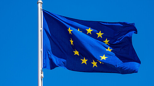 Das Foto zeigt eine Europaflagge, die im Wind flattert.