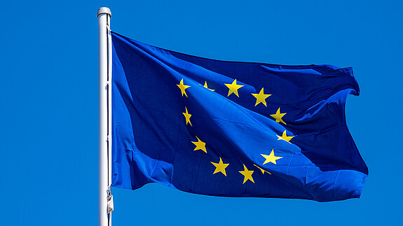 Das Foto zeigt eine Europaflagge, die im Wind flattert.