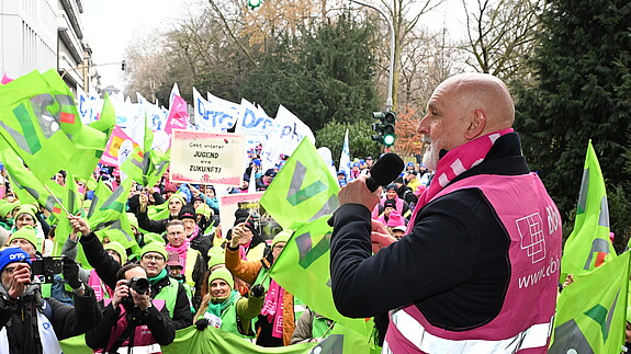 Ein Mann spricht auf einer Demo in ein Mikrofon