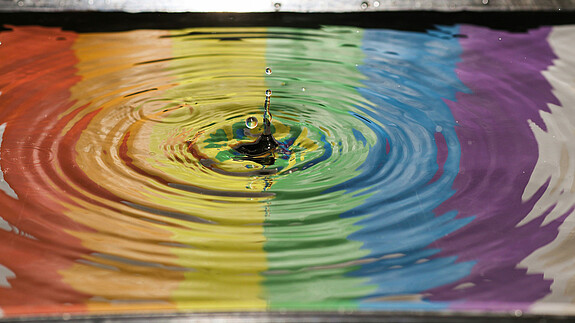 Foto zum Thema "Diversity-Day 2025": Zu sehen sind Regenbogen-Farben, die sich im Wasser spiegeln.