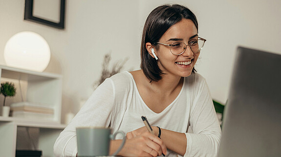 Homeoffice ist Attraktivitätsfaktor für den öffentlichen Dienst Das Foto zeigt eine Frau, die im Homeoffice ist und gerade an einer Videokonferenz teilnimmt.