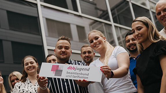 START-Broschüre - dbb jugend Zu sehen sind Mitglieder der dbb jugend mit einem Schild, auf dem "dbb jugend" steht.