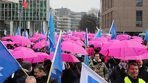 Demo Hamburg Es ist ein Demozug zu sehen, auf dem viele pinke Regenschirme gespannt wurden.