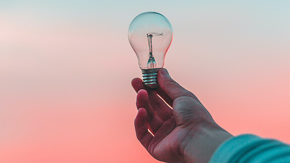Glühbirne im Licht Eine Glühbirne wird ins Licht gehalten