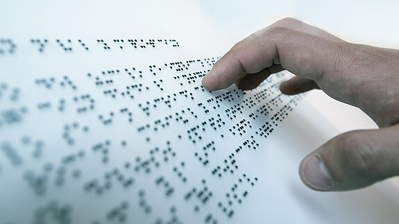 Bessere Arbeitsmarktintegration für Menschen mit Behinderungen Hand auf Blindenschrift