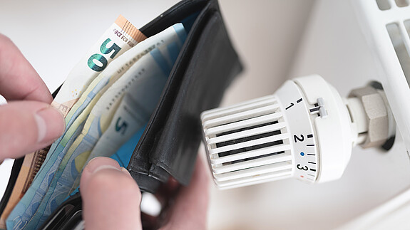 Ein Heizkörper und ein offenes Portemonnaie