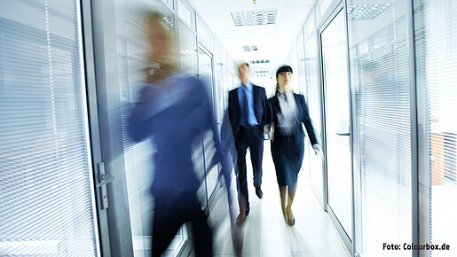 Menschen gehen durch ein Glasgebäude