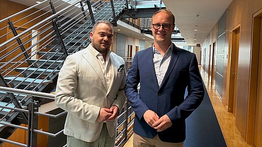 Das Bild zeigt den Vorsitzenden der dbb jugend Matthäus Fandrejewski mit dem beamtenpolitischen Sprecher der Grünen Marcel Emmerich in einem Treppenhaus.